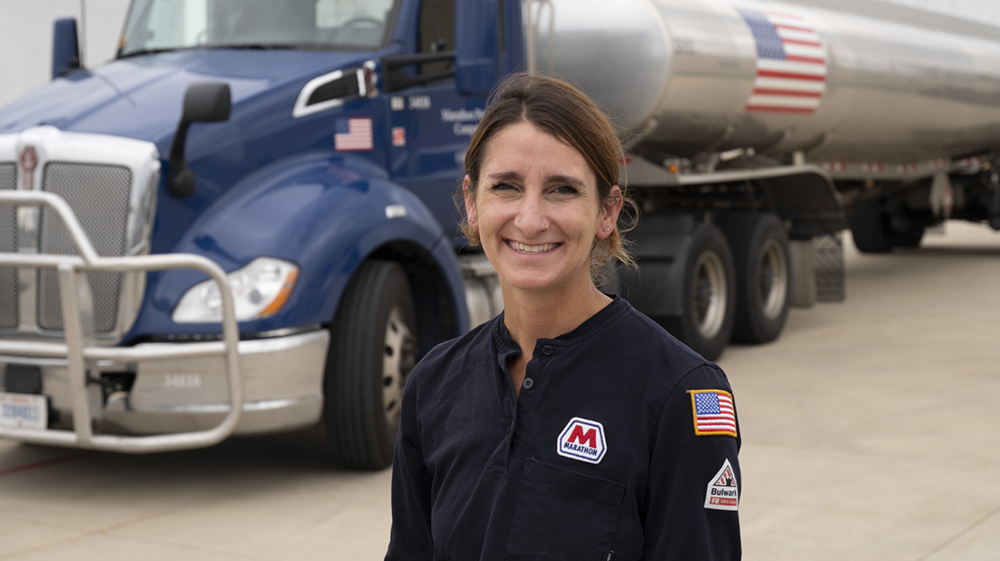transport Driver Hilary Esselstein standing in front of a Marathon Tanker Truck